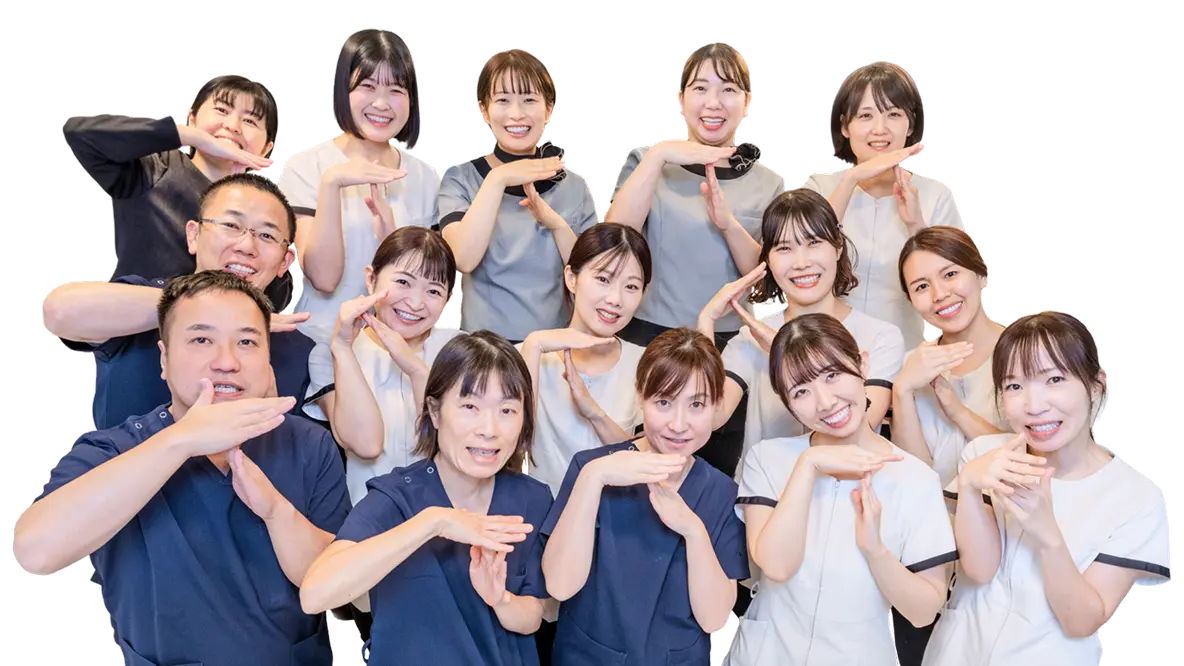 お揃いのユニフォームを着用し、手でポーズを作る田岡歯科矯正歯科の歯科医師・歯科助手・受付スタッフの集合写真