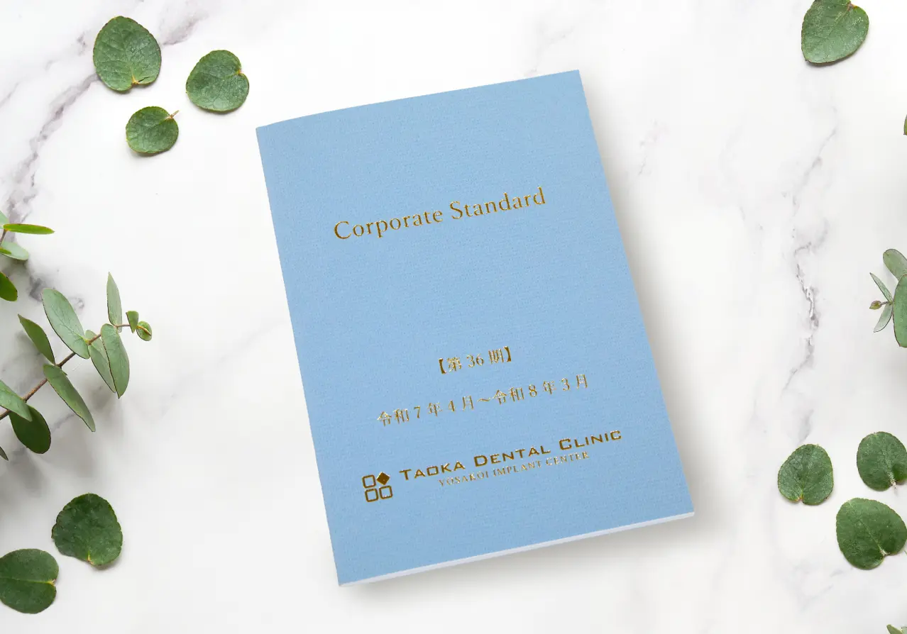 水色の表紙に金文字でCorporate Standardと記された田岡歯科矯正歯科のクレド冊